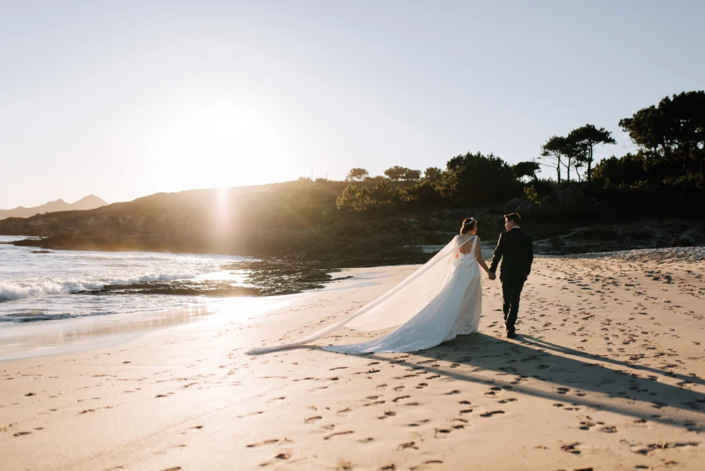 Pareja de recién casados caminando en la playa en luna de miel